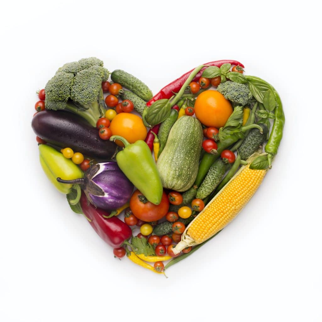 Heart shape frame of fresh vegetables on white background